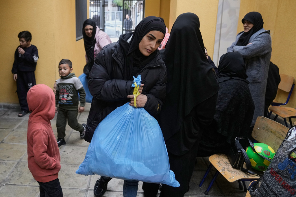 Displaced people fleeing Israeli airstrikes in southern Lebanon and Dahiyeh, Beirut's southern suburbs, arrive at a school turned into a shelter in Beirut, Lebanon, Saturday, March 7, 2026. (AP Photo/Bilal Hussein)