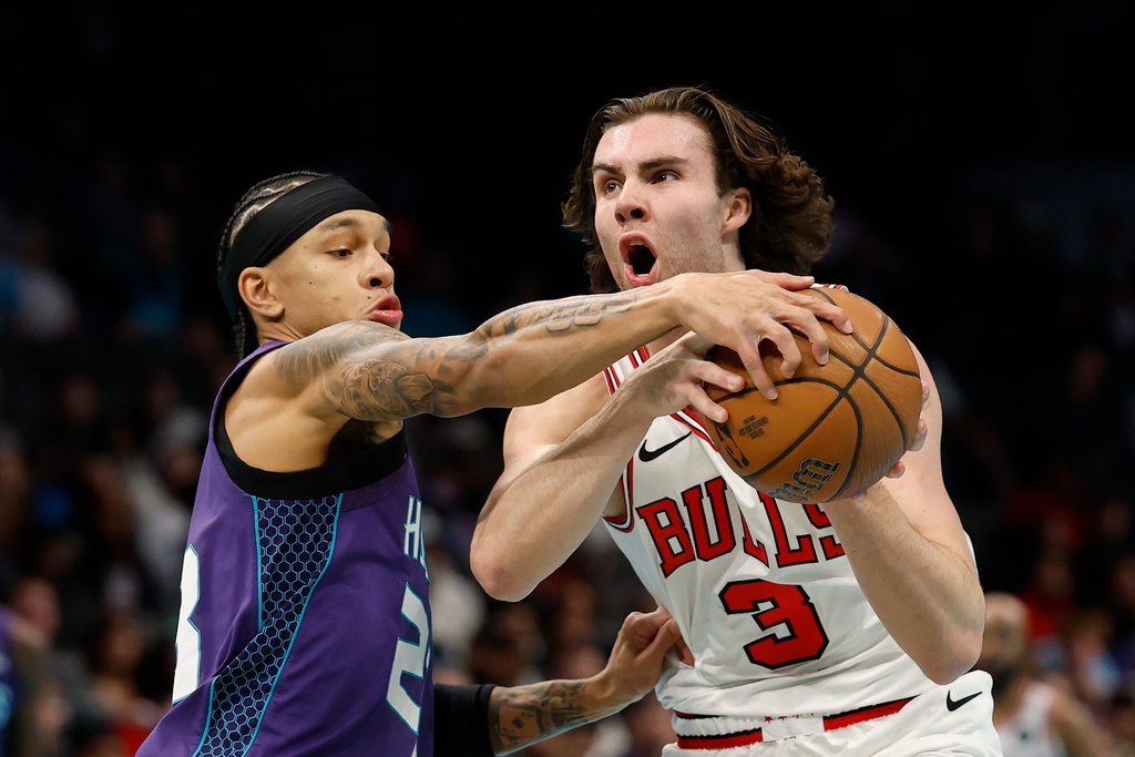 Chicago Bulls guard Josh Giddey (3) drives to the basket against Charlotte Hornets guard Tre Mann during the first half of an NBA Cup basketball game in Charlotte, N.C., Friday, Nov. 28, 2025. (AP Photo/Nell Redmond)