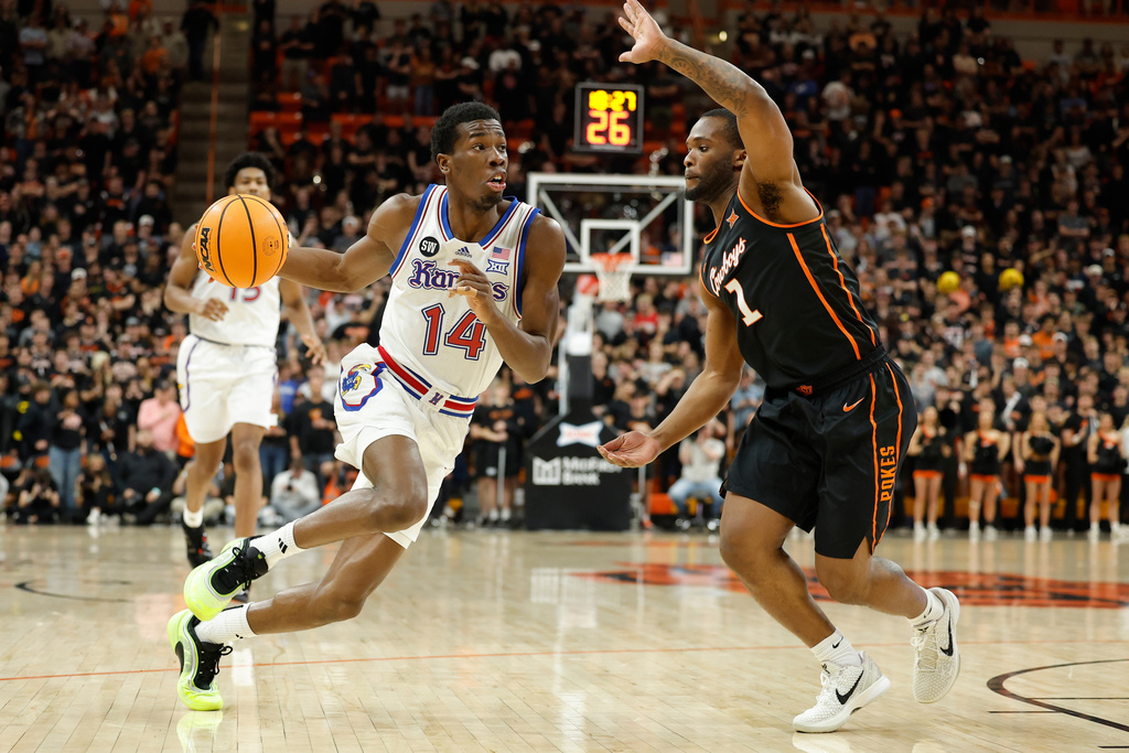 Kansas guard Melvin Council Jr. (14) drives to the basket as Oklahoma State guard Kanye Clary (1) defends during the first half of a NCAA college basketball game Wednesday, Feb. 18, 2026, in Stillwater, Okla. (AP Photo/Alonzo Adams)