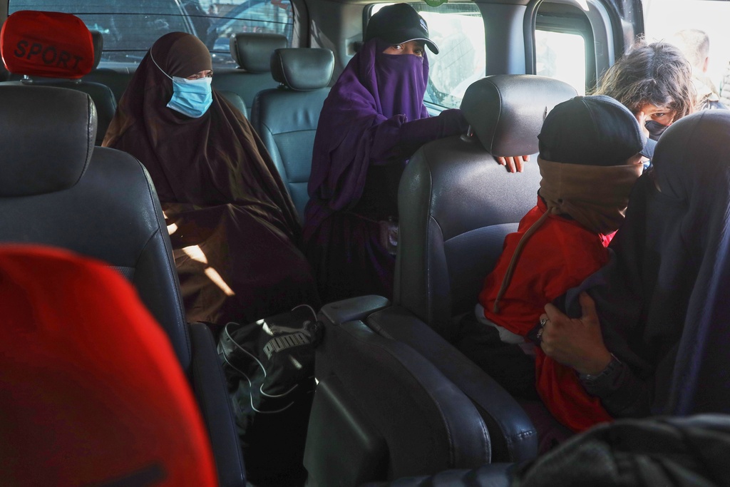 Family members of suspected Islamic State militants who are Australian nationals sit in a van heading to the airport in Damascus during the first repatriation operation of the year, at Roj Camp in eastern Syria, Monday, Feb. 16, 2026. Thirty-four Australian citizens from 11 families departed the camp. (AP Photo/Baderkhan Ahmad)