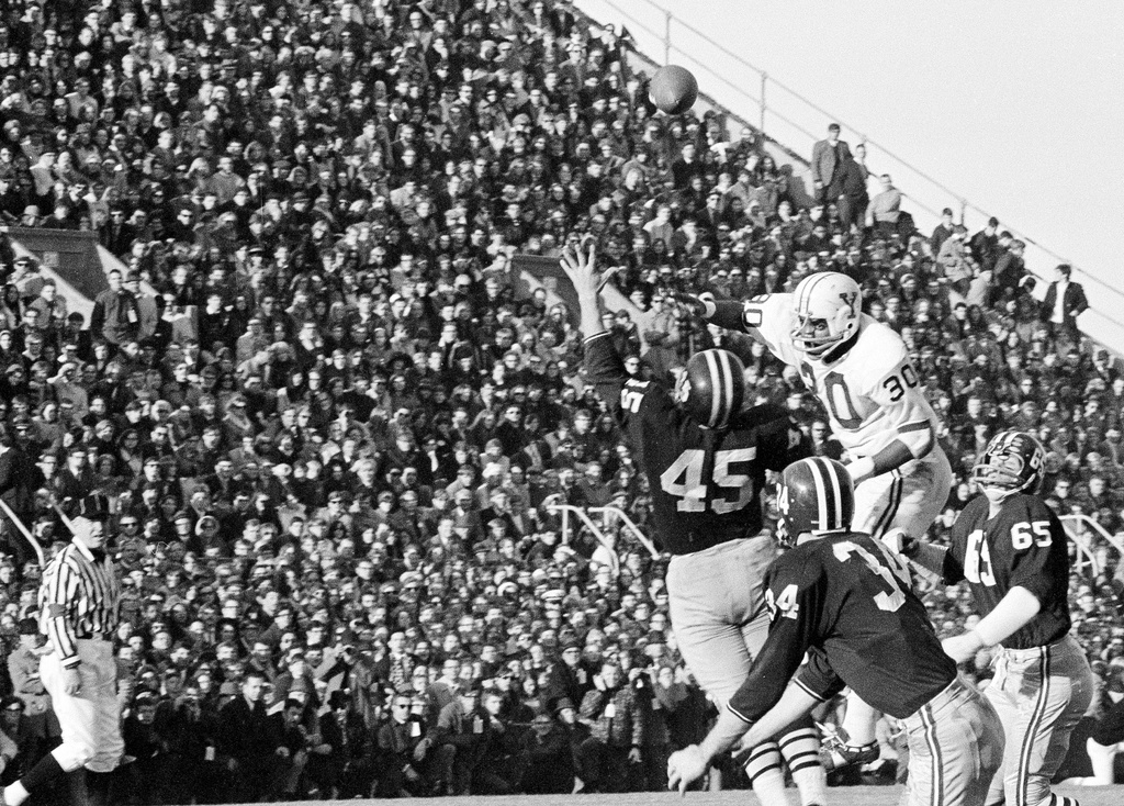 FILE - Harvard players defend a Brian Dowling pass meant for Yale's Calvin Hill (30) in the second quarter of a college football game at Harvard Stadium in Cambridge, Mass., Nov. 23, 1968. (AP Photo/File)