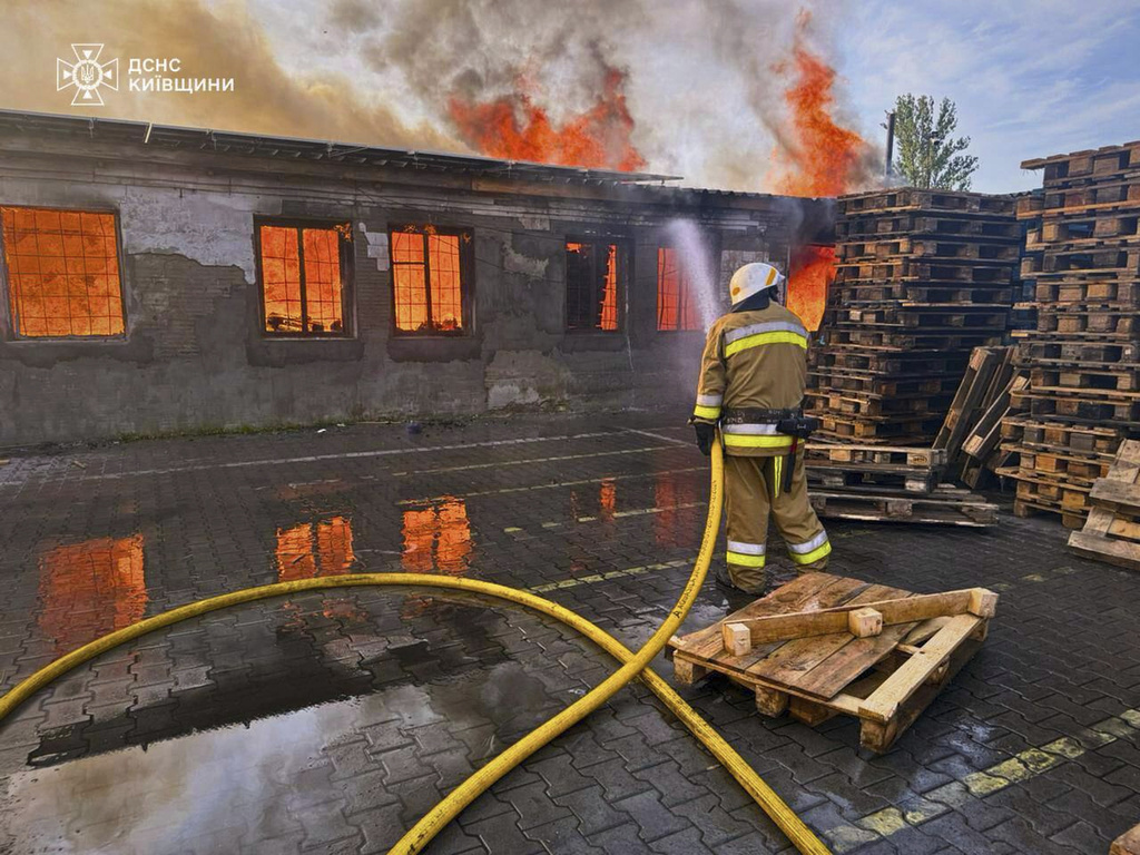 In this photo provided by the Ukrainian Emergency Service, a firefighter puts out the fire following a Russian attack in Kyiv region, Ukraine, Wednesday, July 9, 2025. (Ukrainian Emergency Service via AP)