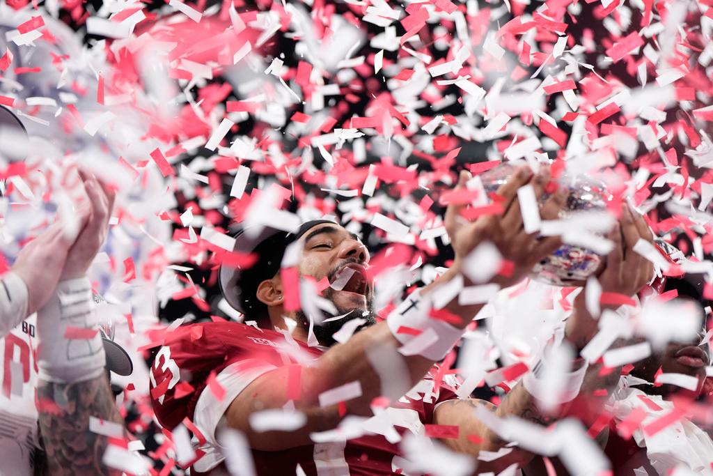 Indiana wide receiver Elijah Sarratt (13) holds up the trophy after the Peach Bowl NCAA college football playoff semifinal against Oregon, Friday, Jan. 9, 2026, in Atlanta. (AP Photo/Brynn Anderson)