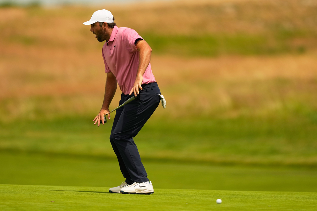 Scottie Scheffler reacts after missing a putt on the 13th hole during the first round of the U.S. Open golf tournament at Shinnecock Hills Golf Club in Southampton, N.Y., Thursday, June 18, 2026.(AP Photo/Gerald Herbert)