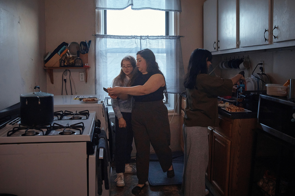 Gulhayo Yuldosheva helps get her children ready for school in an apartment building where tenants report maintenance issues and pest infestations, in the Bronx borough of New York, Tuesday, March 17, 2026. (AP Photo/Andres Kudacki)