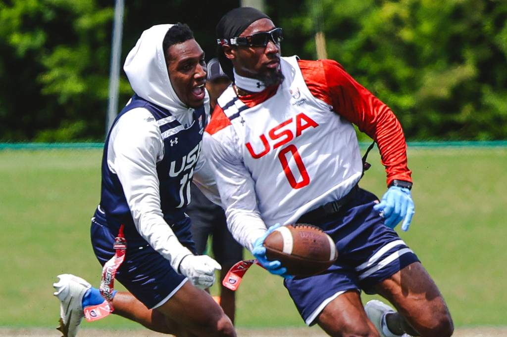 In this image provided by USA Football, Tyler Davis, front, avoids a teammate during flag football practice for the United States national team in Charlotte, N.C. (Lester Barnes/USA Football via AP)