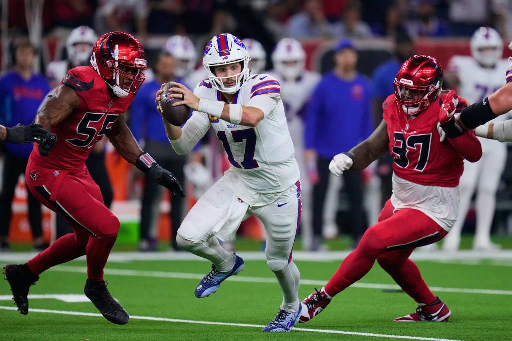 Buffalo Bills quarterback Josh Allen (17) is pressured out of the pocket by Houston Texans' Danielle Hunter (55) and Mario Edwards Jr. (97) in the second half of an NFL football game Thursday, Nov. 20, 2025, in Houston. (AP Photo/Eric Christian Smith)