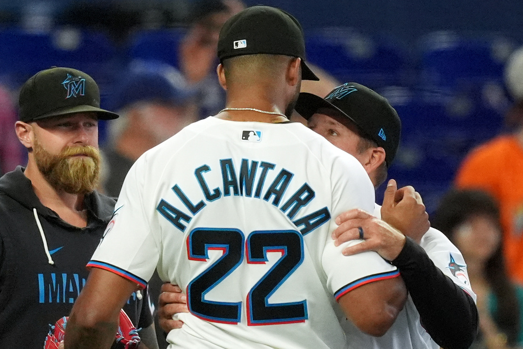 Miami Marlins manager Clayton McCullough, right, embraces starting pitcher Sandy Alcantara after he pitched the entirety of a baseball game against the Chicago White Sox, Wednesday, April 1, 2026, in Miami. (AP Photo/Rebecca Blackwell)
