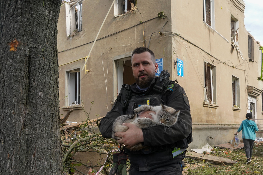 A policeman rescues a cat during search and rescue works in the damaged residential building following Russia's missile attack in Kharkiv, Ukraine, Saturday, June 20, 2026. (AP Photo/Andrii Marienko)