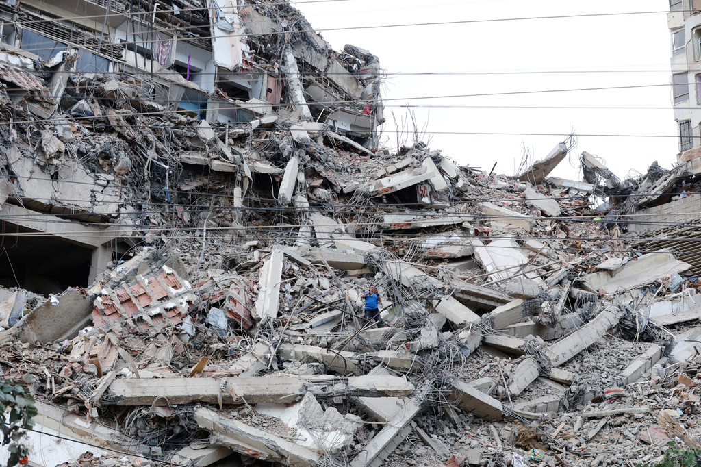 A man walks among the rubble of a building that collapsed in earthquakes the previous day in La Guaira, Venezuela, Thursday, June 25, 2026. (AP Photo/Pedro Mattey)