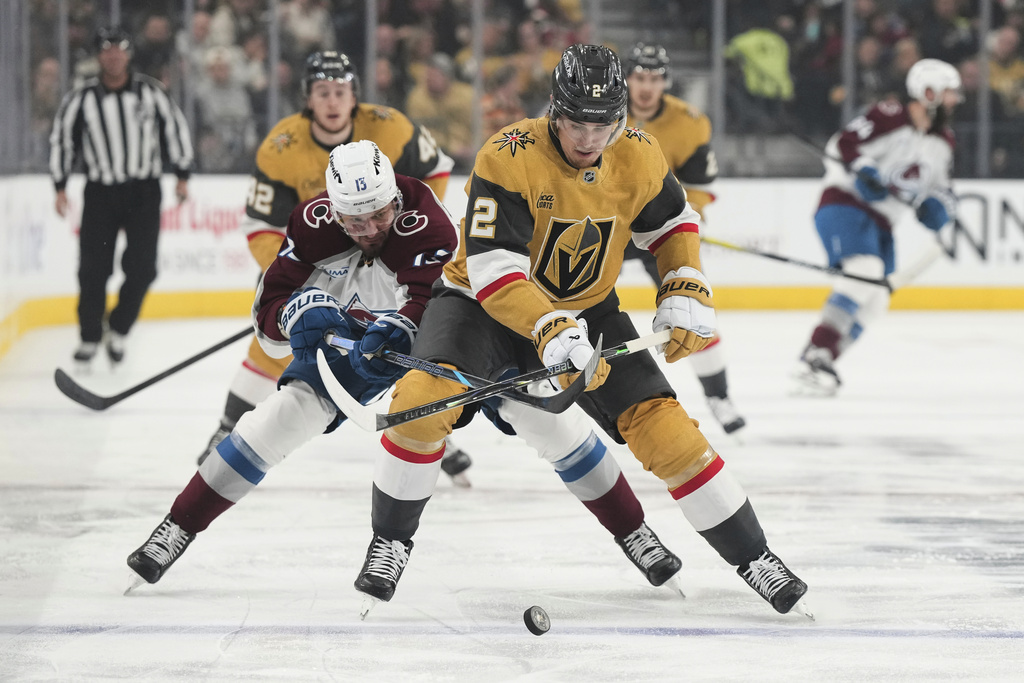 Colorado Avalanche right wing Valeri Nichushkin (13) and Vegas Golden Knights defenseman Zach Whitecloud (2) vie for the puck during the first period of an NHL hockey game Saturday, Dec. 27, 2025, in Las Vegas. (AP Photo/Candice Ward)