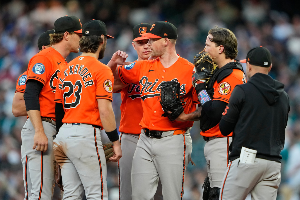 Baltimore Orioles starting pitcher Kyle Bradish, center, greets teammates, including third baseman Blaze Alexander (23) as he is relieved against the Seattle Mariners during the eighth inning of a baseball game, Wednesday, June 17, 2026, in Seattle. (AP Photo/Lindsey Wasson)