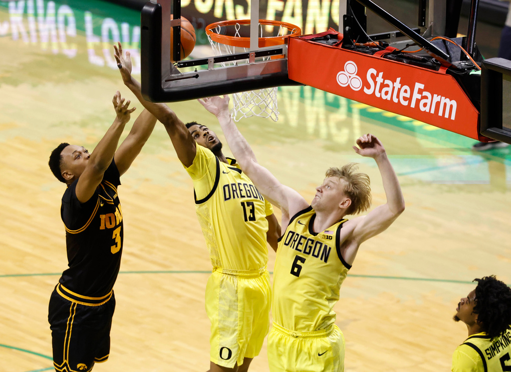 Oregon forwards Sean Stewart (13) and Oleksandr Kobzystyi (6) go for a rebound against Iowa forward Cam Manyawu (3) in the first half of an NCAA college basketball game in Eugene, Ore., Sunday, Feb. 1, 2026. (AP Photo/Thomas Boyd)