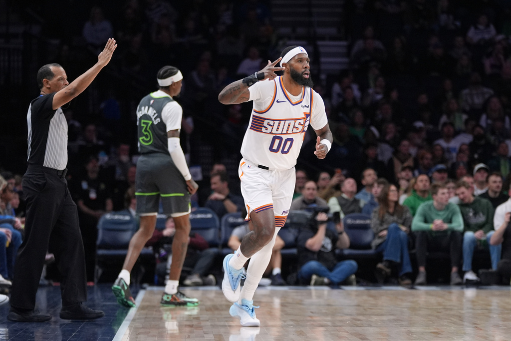 Phoenix Suns forward Royce O'Neale (00) gestures after making a 3-point shot during the first half of an NBA basketball game against the Minnesota Timberwolves, Tuesday, March 17, 2026, in Minneapolis. (AP Photo/Abbie Parr)