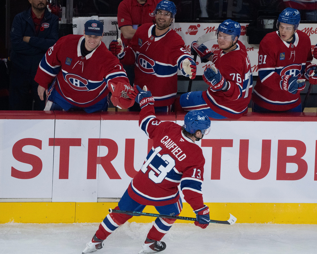 Montreal Canadiens' Cole Caufield (13) celebrates his goal over Ottawa Senators goaltender Linus Ullmark (not shown) with the bench during first period NHL hockey action in Montreal on Saturday, Nov. 1, 2025. (Christinne Muschi/The Canadian Press via AP)