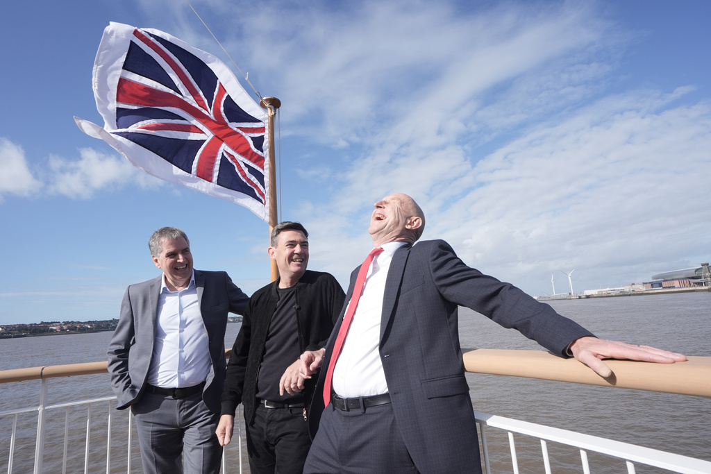 Britain's Prime Minister Andy Burnham, center, Chancellor of the Exchequer John Healey, right, and Liverpool City Region Mayor Steve Rotheram on the new Royal Daffodil Ferry, ahead of the Labour Party Conference at the ACC Liverpool, in Liverpool, England, Saturday, Sept. 26, 2026. (Stefan Rousseau/PA via AP)