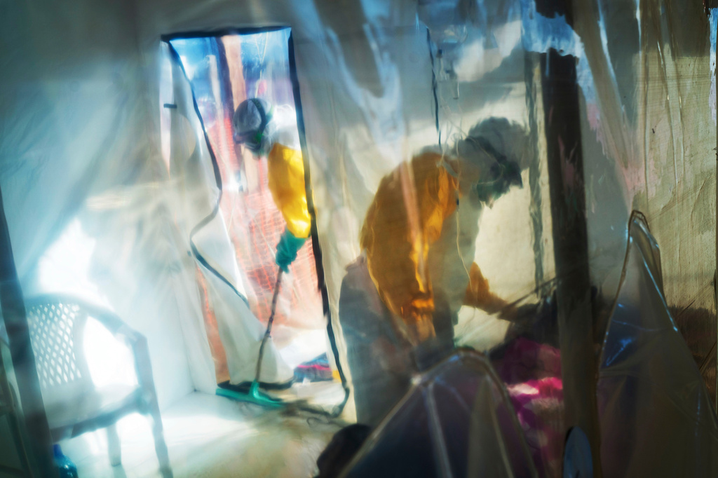 FILE - Health workers wearing protective suits tend to an Ebola victim kept in an isolation tent in Beni, Congo, July 13, 2019. (AP Photo/Jerome Delay, File)