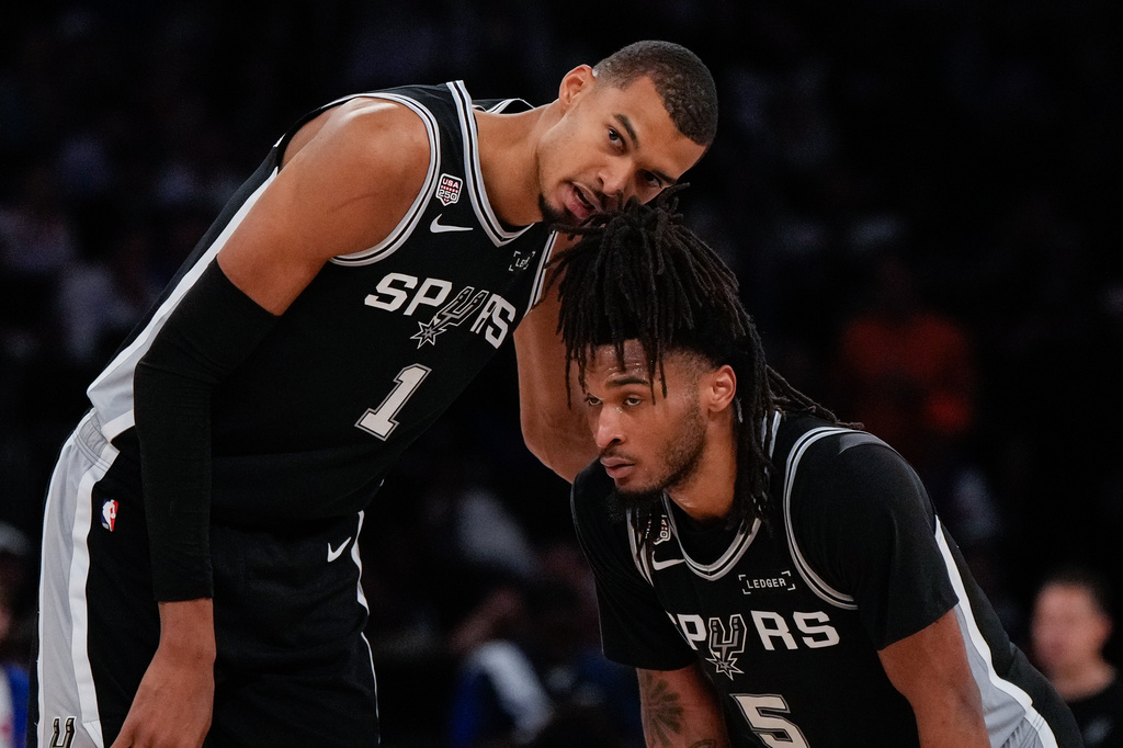 San Antonio Spurs forward Victor Wembanyama (1) talks with guard Stephon Castle during second half of Game 3 of the NBA Finals basketball series against the New York Knicks, Monday, June 8, 2026, in New York. (AP Photo/Ross D. Franklin)