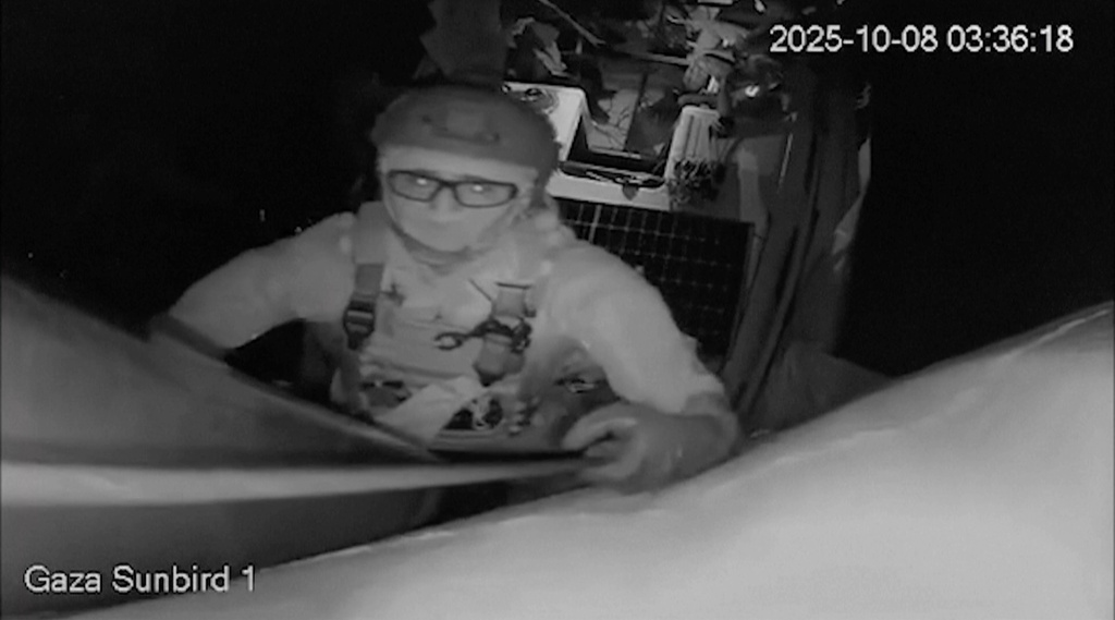 This image obtained from live stream footage from Gaza Sunbird vessel, one of the nine boats taking part in the Freedom Flotilla Coalition & Thousand Madleens to Gaza, shows an Israeli soldier trying to reach the camera onboard Gaza Sunbird vessel, in Eastern Mediterranean sea, on Wednesday, Oct. 8, 2025. (Freedom Flotilla Coalition via AP)