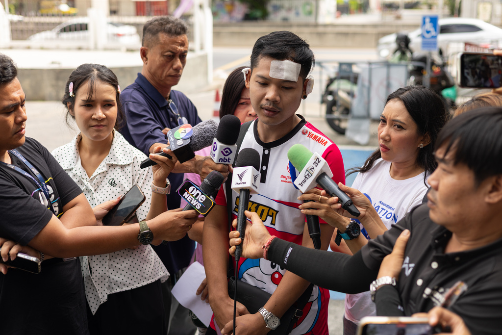 Natthaphong Lakhorn, a 26-year-old survivor of the Rong Beer Na Ladprao bar fire, speaks to journalists outside the Phahonyothin Police Station in Bangkok, Thailand, Wednesday, July 15, 2026. (AP Photo/Anton L. Delgado)