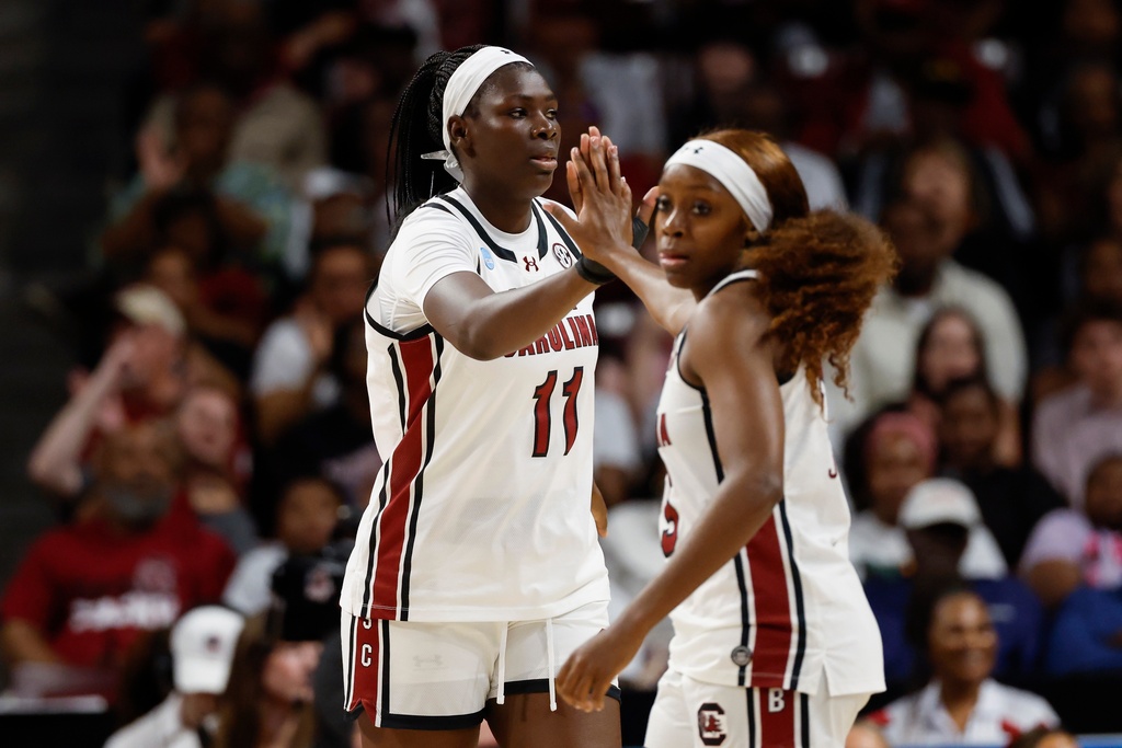 South Carolina center Madina Okot (11) high-fives guard Raven Johnson during the first half against Southern California in the second round of the NCAA college basketball tournament Monday, March 23, 2026, in Columbia, S.C. (AP Photo/Nell Redmond)
