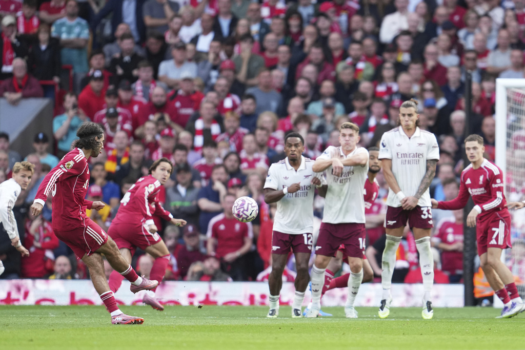Liverpool's Dominik Szoboszlai, left, shoots to score his sides first goal during the English Premier League soccer match between FC Liverpool and FC Arsenal in Liverpool, England, Sunday, Aug. 31, 2025. (AP Photo/Jon Super)