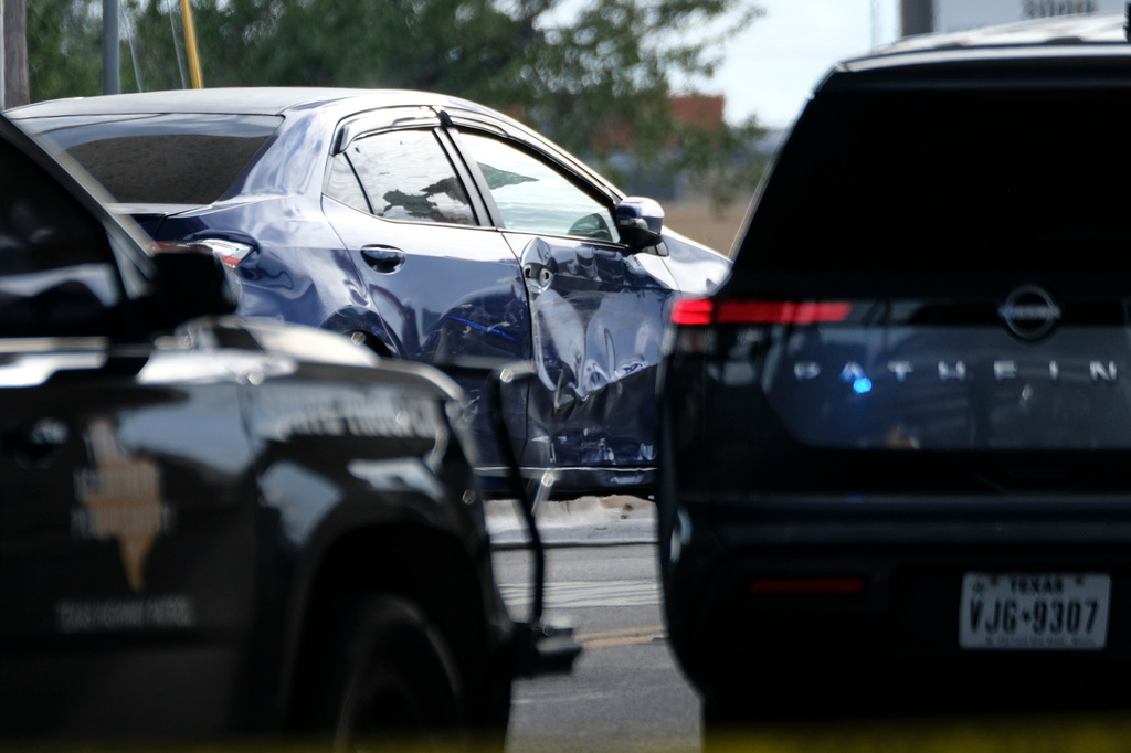 A vehicle, center, where a suspect was shot by an ICE officer is seen under an overpass, Sunday, Sept. 20, 2026, in Austin, Texas. (AP Photo/Joel Angel Juarez)