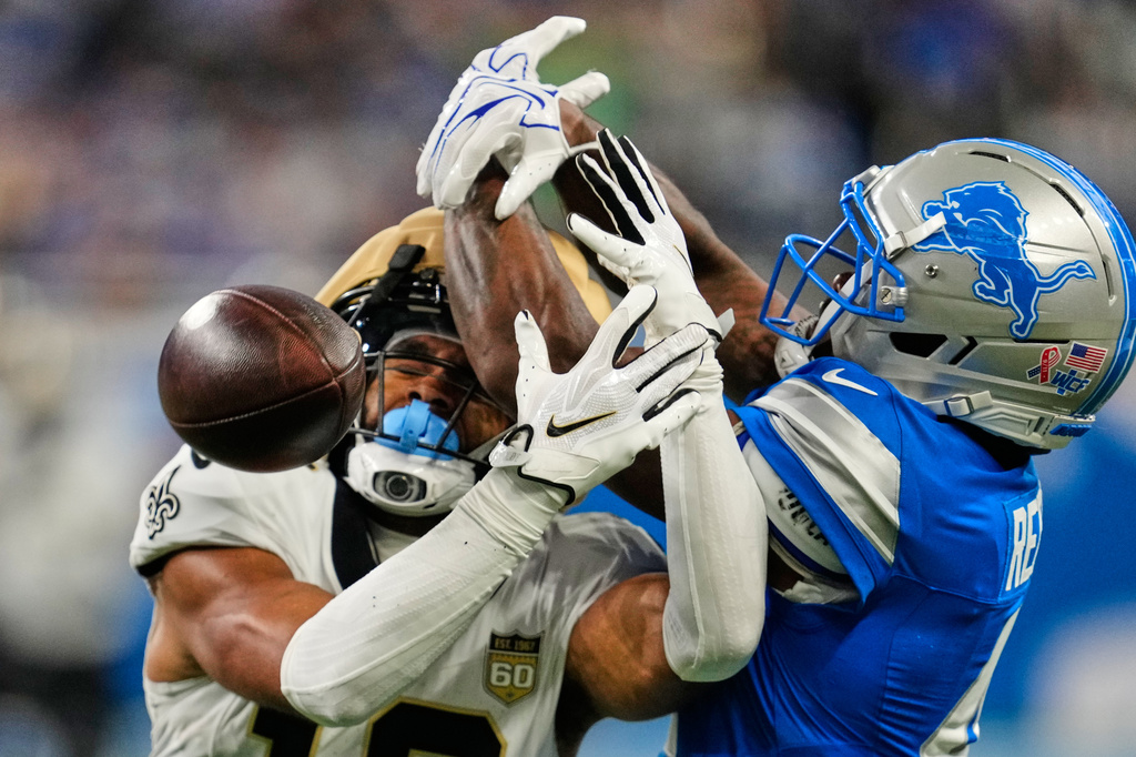 Detroit Lions cornerback D.J. Reed (4) breaks up a pass intended for New Orleans Saints wide receiver Chris Olave (12) in the first half of an NFL football game, Sunday, Sept. 13, 2026, in Detroit. (AP Photo/Paul Sancya)