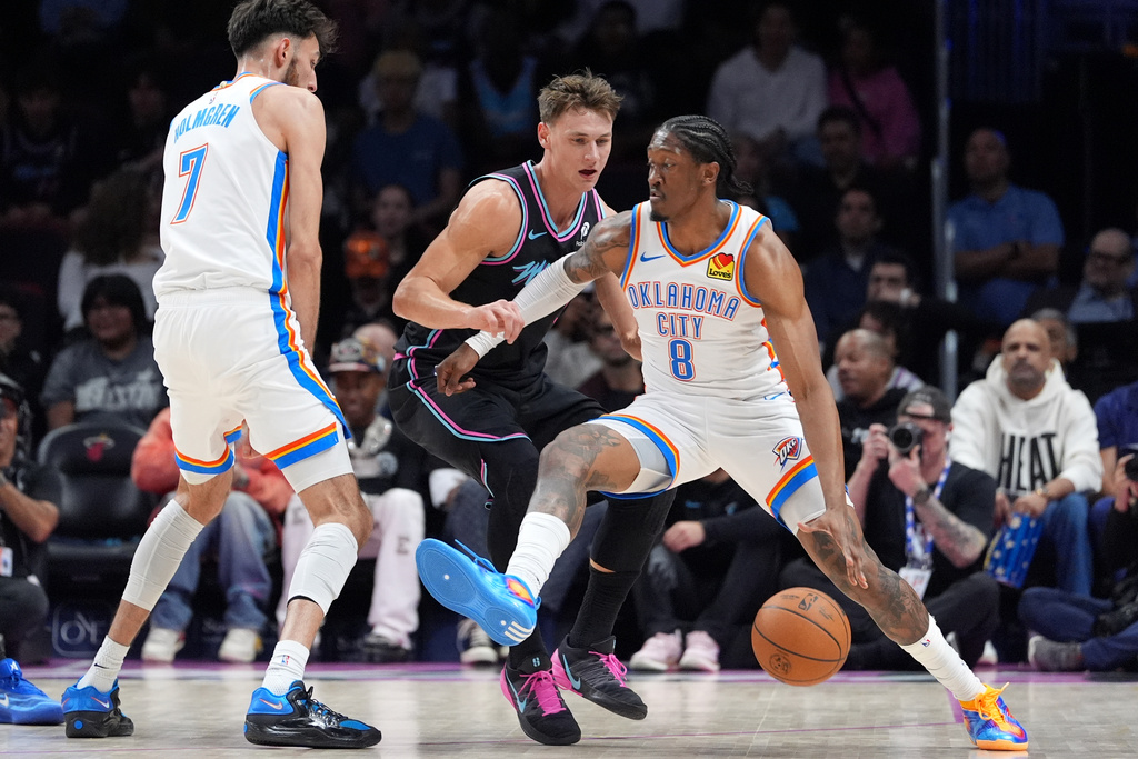 Oklahoma City Thunder guard Jalen Williams (8) holds off Miami Heat guard Pelle Larsson as he looks for an opening during the first half of an NBA basketball game, Saturday, Jan. 17, 2026, in Miami. (AP Photo/Rebecca Blackwell)