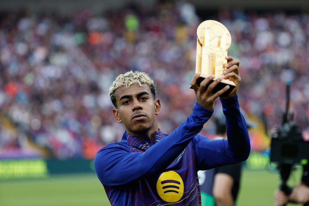 Barcelona's Lamine Yamal shows the Kopa Trophy prior to a Spanish La Liga soccer match between FC Barcelona and Real Sociedad at the Lluis Companys Olympic Stadium in Barcelona, Spain, Sunday, Sept. 28, 2025. (AP Photo/Joan Monfort)