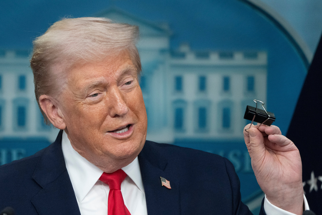 President Donald Trump holds a binder clip as he speaks during a press briefing at the White House in Washington, Tuesday, Jan. 20, 2026. (AP Photo/Mark Schiefelbein)