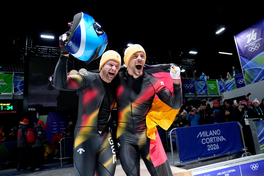 Germany's gold medalists Johannes Lochner, left, and Georg Fleischhauer celebrate at the finish after the two man bobsled competition at the 2026 Winter Olympics, in Cortina d'Ampezzo, Italy, Tuesday, Feb. 17, 2026. (AP Photo/Alessandra Tarantino)