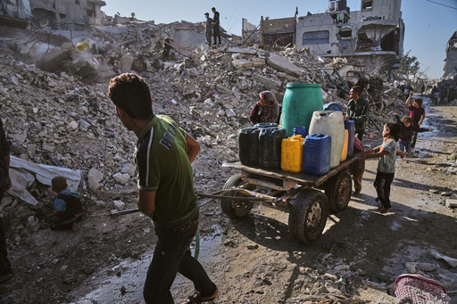 Palestinians carry water amid the ruins of Gaza City, Sunday, Oct. 26, 2025. (AP Photo/Jehad Alshrafi) Palestinians carry water amid the ruins of Gaza City, Sunday, Oct. 26, 2025. (AP Photo/Jehad Alshrafi)