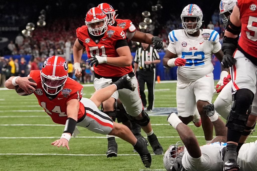 Georgia quarterback Gunner Stockton (14) dives into the end zone for a touchdown against Mississippi during the first half of the Sugar Bowl NCAA college football playoff quarterfinal game, Thursday, Jan. 1, 2026, in New Orleans. (AP Photo/Gerald Herbert)