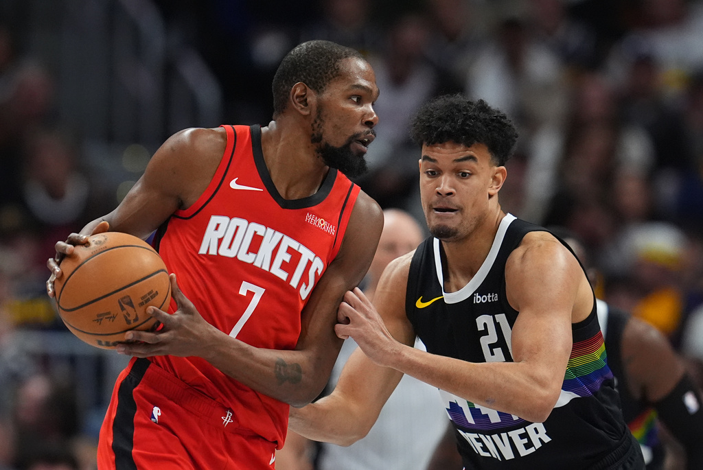 Houston Rockets forward Kevin Durant, left, looks to pass the ball as Denver Nuggets forward Spencer Jones defends in the first half of an NBA basketball game Saturday, Dec. 20, 2025, in Denver. (AP Photo/David Zalubowski)
