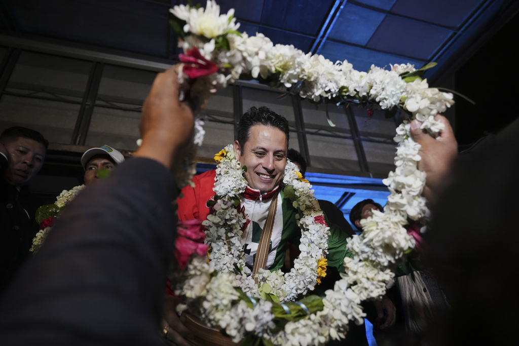 A supporter gifts vice-presidential candidate Edman Lara a flower necklace during a rally a day after he and his running mate Rodrigo Paz won a plurality in the first round of the presidential election, in El Alto, Bolivia, Monday, Aug. 18, 2025. (AP Photo/Natacha Pisarenko)