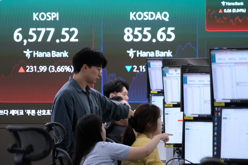 Currency traders watch monitors near a screen showing the Korea Composite Stock Price Index (KOSPI) at the foreign exchange dealing room of the Hana Bank headquarters in Seoul, South Korea, Wednesday, Aug. 12, 2026. (AP Photo/Ahn Young-joon)