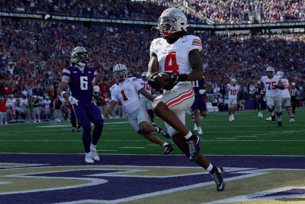 FILE - Ohio State wide receiver Jeremiah Smith (4) scores on a pass run play against the Washington during the first half of an NCAA college football game, Saturday, Sept. 27, 2025, in Seattle. (AP Photo/John Froschauer, File)