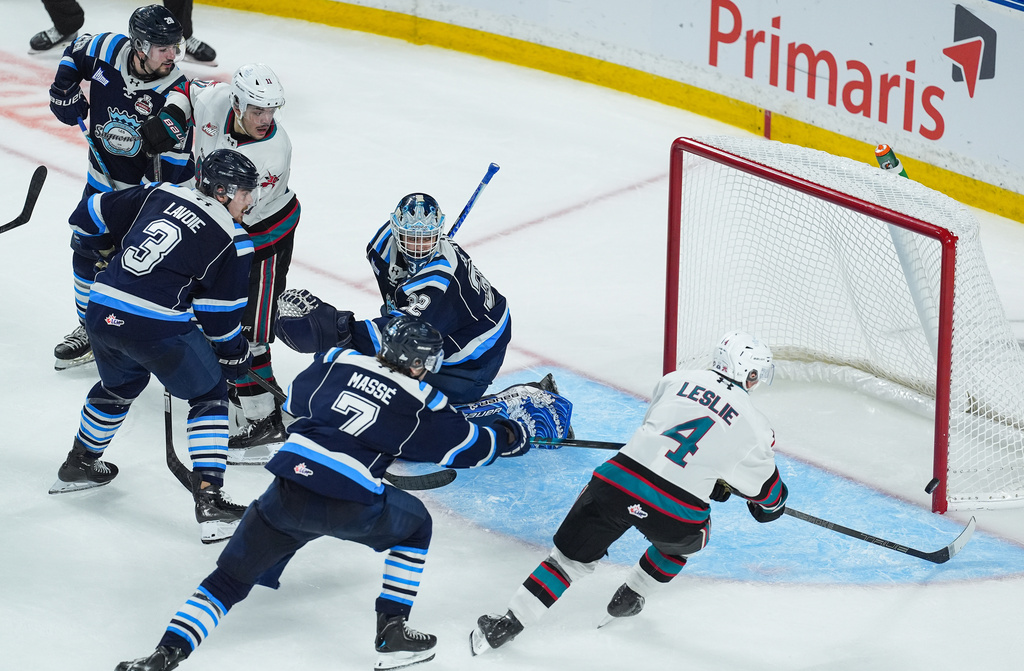 Kelowna Rockets' Mazden Leslie (4) scores against Chicoutimi Sagueneens' goalie Lucas Beckman (32) as Maxim Masse (7), Tomas Lavoie (3), Emmanuel Vermette (28) and Kelowna's Tij Iginla (11) watch in Kelowna, British Columbia, Sunday, May 24, 2026. (Darryl Dyck/The Canadian Press via AP)