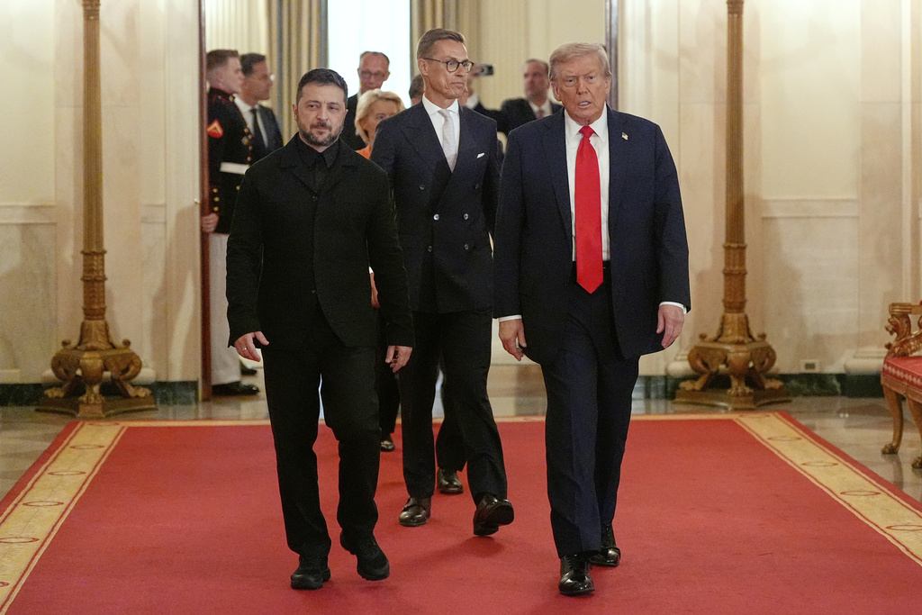 Ukraine's President Volodymyr Zelenskyy, from left, Finland's President Alexander Stubb and President Donald Trump walk through the Cross Hall of the White House, Monday, Aug. 18, 2025, in Washington. (AP Photo/Alex Brandon)