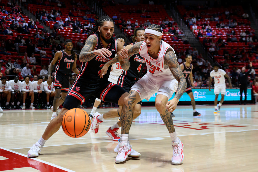 Houston guard Emanuel Sharp, front left, and Utah guard Terrence Brown, front right, battle for possession of the loose ball during the second half of an NCAA college basketball game, Tuesday, Feb. 10, 2026, in Salt Lake City. (AP Photo/Tyler Tate)