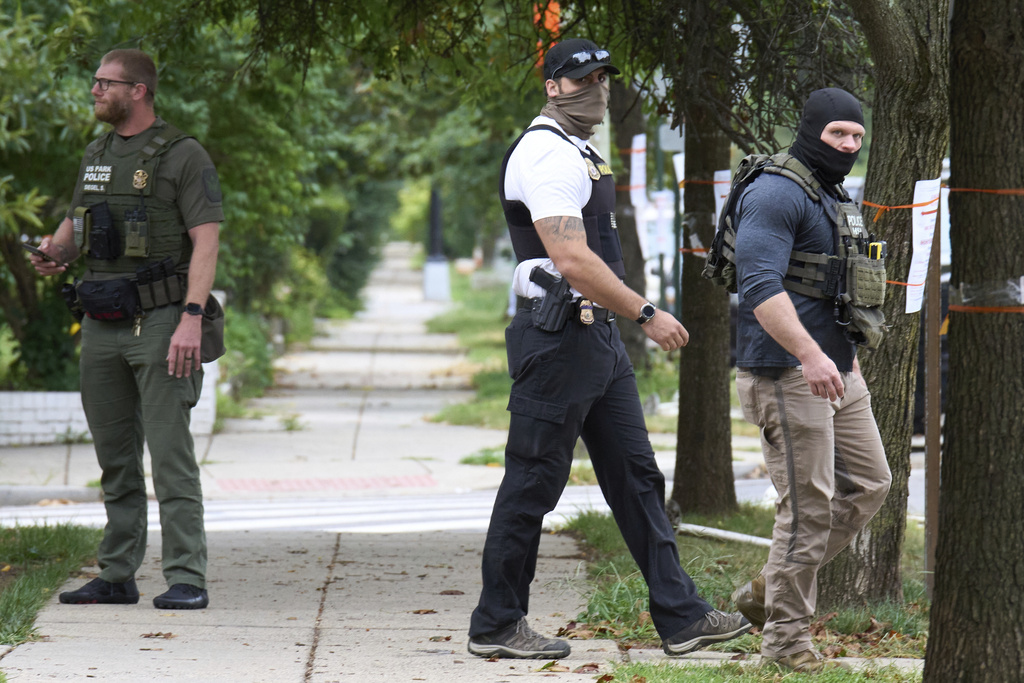 Armed officers from several federal agencies including U.S. Marshals, FBI, HSI, and Park Police, leave an apartment complex after arresting a man from within the apartment complex, Tuesday, August 19, 2025, in the Petworth neighborhood of northwest Washington. (AP Photo/Jacquelyn Martin)