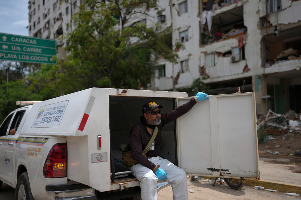 Forensic technician Joel Mirabal rides through the area struck by the earthquakes collecting bodies recovered from the rubble in La Guaira, Venezuela, Tuesday, June 30, 2026. (AP Photo/Matias Delacroix)