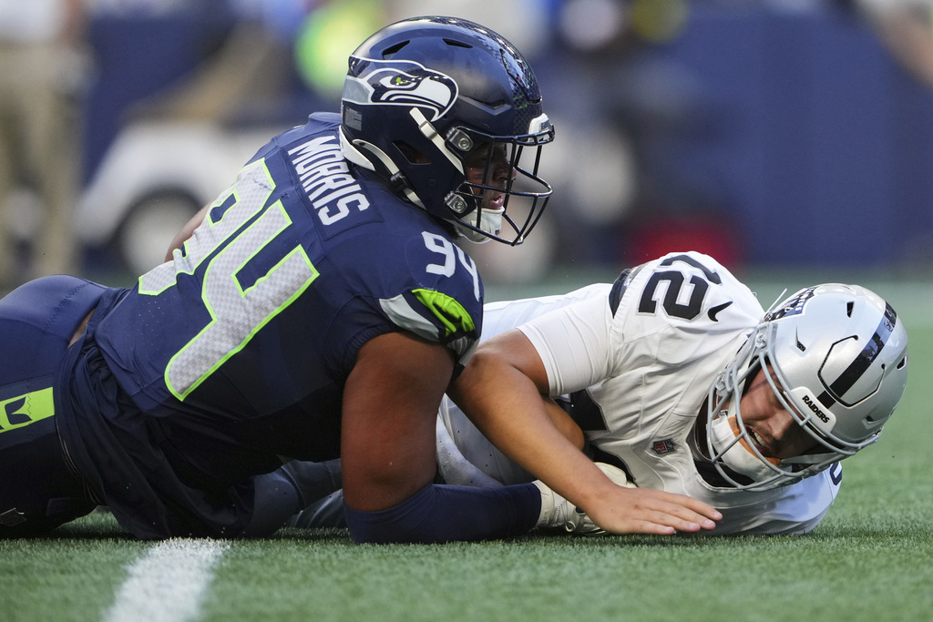 Seattle Seahawks defensive end Mike Morris (94) forces an incomplete against Las Vegas Raiders quarterback Aidan O'Connell (12) during the first half of an NFL preseason football game Thursday, Aug. 7, 2025, in Seattle. (AP Photo/Lindsey Wasson)