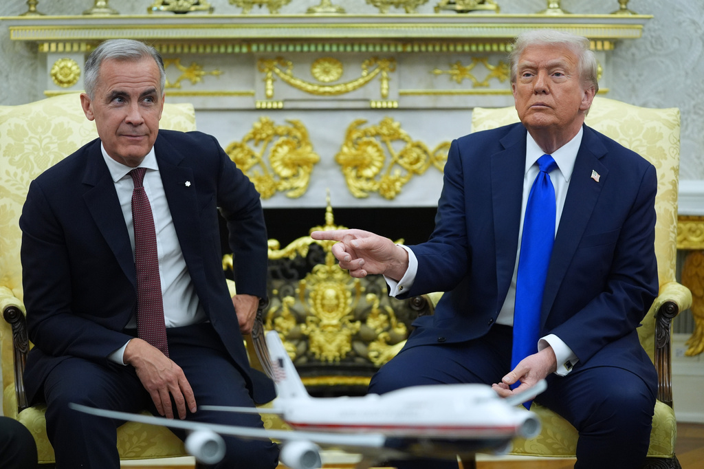 FILE - President Donald Trump gestures alongside Canadian Prime Minister Mark Carney as they meet in the Oval Office of the White House, Oct. 7, 2025, in Washington. (AP Photo/Evan Vucci, File)