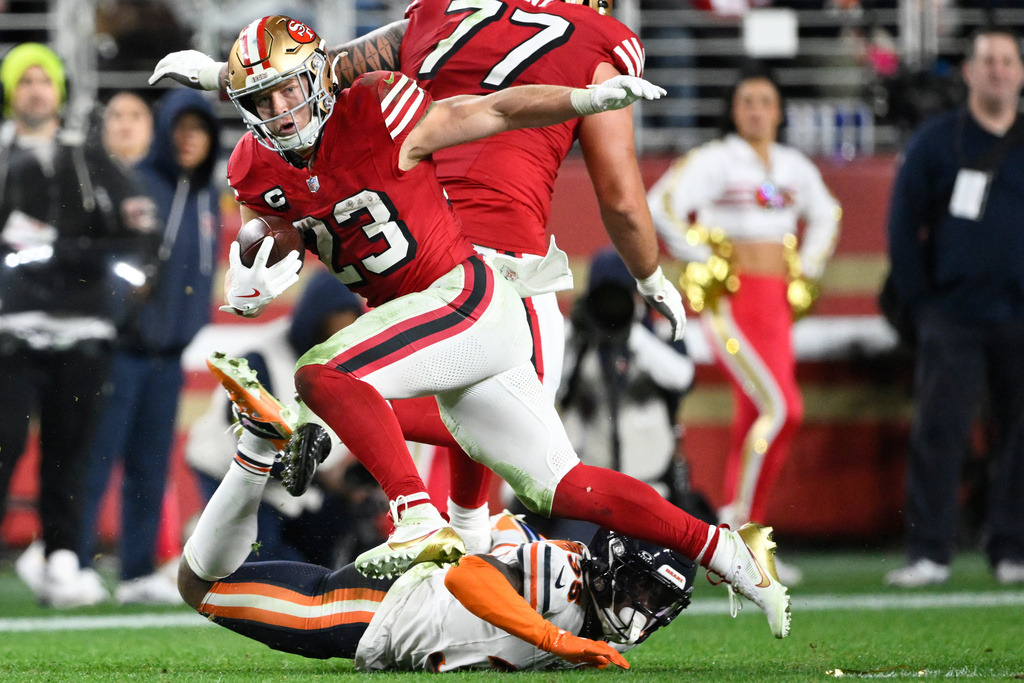 San Francisco 49ers running back Christian McCaffrey (23) runs against Chicago Bears safety C.J. Gardner-Johnson, bottom, during the second half of an NFL football game in Santa Clara, Calif., Sunday, Dec. 28, 2025. (AP Photo/Eakin Howard)