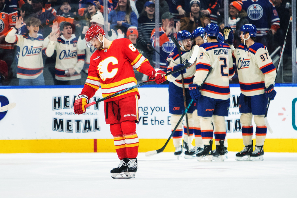 Calgary Flames' Joel Farabee (86) skates off as Edmonton Oilers players celebrate a goal during first period NHL action in Edmonton on Tuesday, Dec. 23, 2025. (Amber Bracken/The Canadian Press via AP)