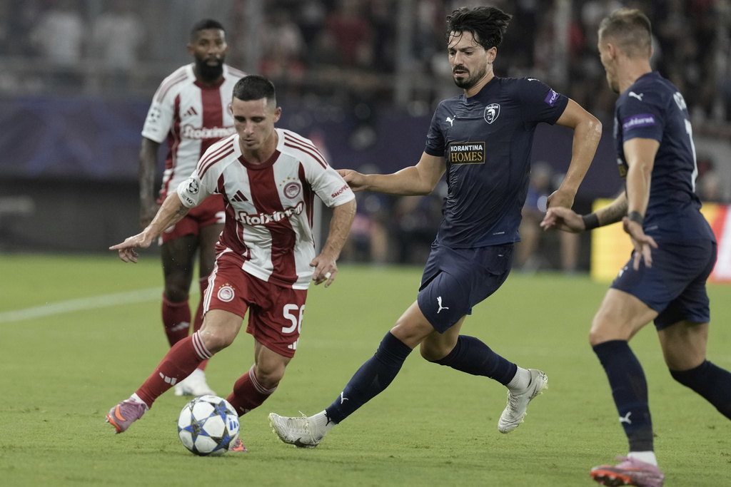 Olympiacos' Daniel Podence fights for the ball against Pafos' Pepe during a Champions League opening phase soccer match between Olympiakos and Pafos at the Georgios Karaiskakis stadium, Piraeus port, near Athens, Greece, Wednesday, Sept. 17, 2025. (AP Photo/Petros Giannakouris)