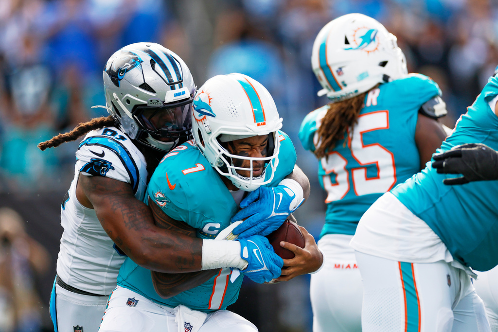 Miami Dolphins quarterback Tua Tagovailoa is sacked by Carolina Panthers linebacker Patrick Jones II during the second half of an NFL football game, Sunday, Oct. 5, 2025, in Charlotte, N.C. (AP Photo/Rusty Jones)