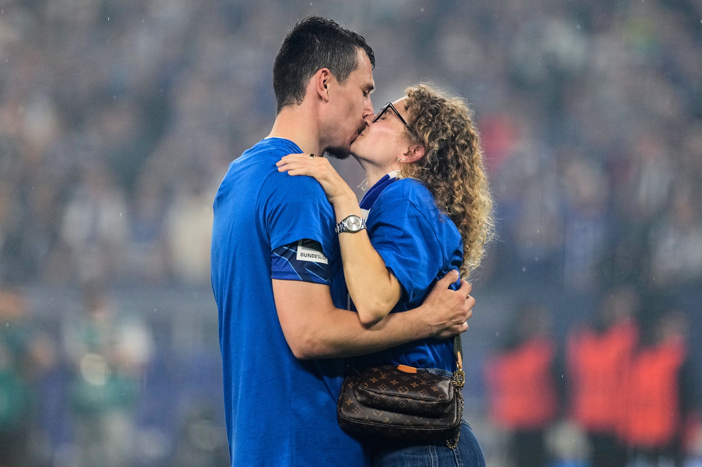 Schalke's Ron Schallenberg is kissed on the pitch after FC Schalke 04 secured promotion to the German Bundesliga by winning the Bundesliga 2 match against Fortuna Duesseldorf at the Arena in Gelsenkirchen, Germany, Saturday, May 2, 2026. (AP Photo/Martin Meissner)